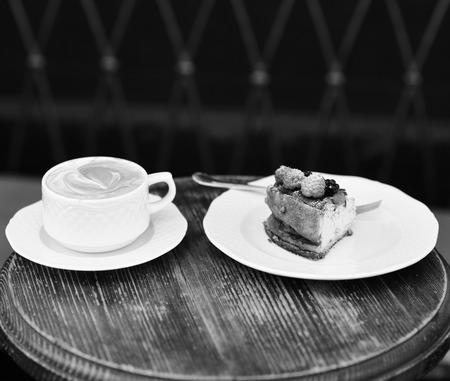 Cheesecake with berries and coffee on wooden tableの写真素材