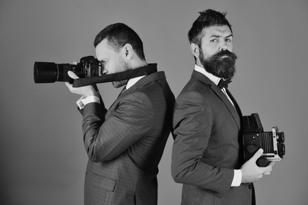 photographers working. Men with beards hold photo cameras on blue backgroundの写真素材