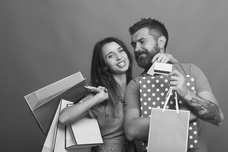 Guy with beard and pretty lady with do shoppingの写真素材