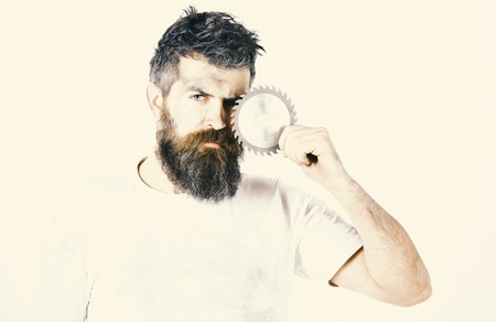 Repairman, foreman holds circular saw blade in front of face.の写真素材