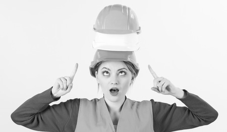 Woman with surprised, confused face pointing at head, white background.の写真素材