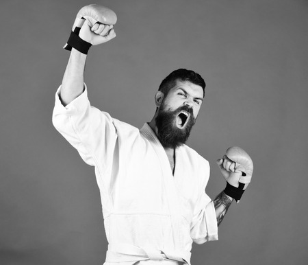 winner is karate. Karate man with angry face in golden boxing gloves.の写真素材