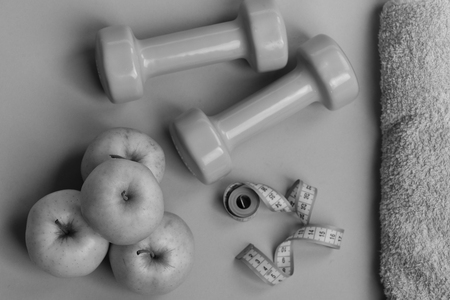 Dumbbells in bright color, measure tape, towel and fruitの写真素材