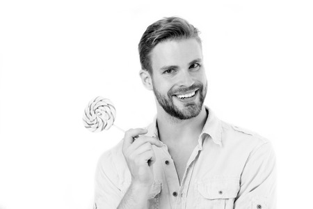 Man smile with candy on stick isolated on white background. Happy macho with lollipop. Food and snack. Unhealthy diet and eating. Lollipop fun, black and whiteの写真素材