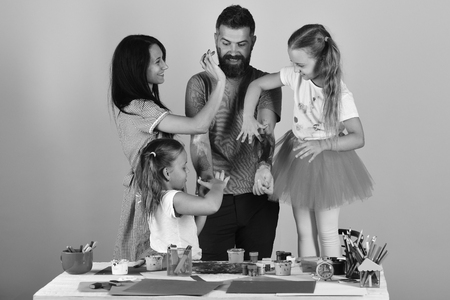 happy family.Parents and children paint on fathers arms with gouacheの写真素材