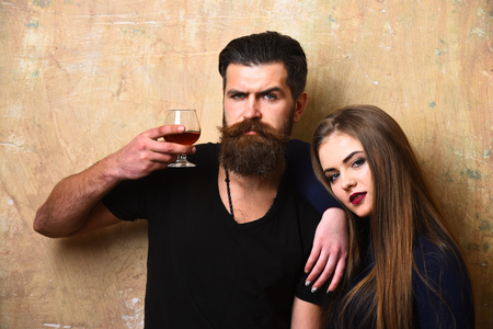 Girlfriend and boyfriend with smiling faces drink cognac.の写真素材