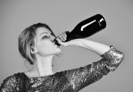 female alcoholism. Woman with serious face drinks expensive cabernet or merlotの写真素材