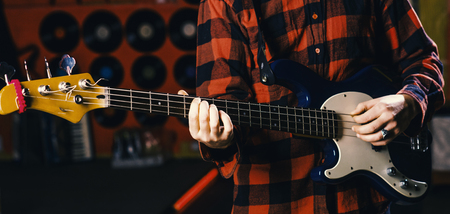 Musician, artist play electric guitar musical instrument. Male hands hold guitar, play music in club...
