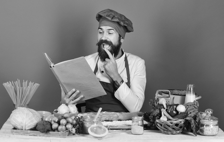 book of recipes. Man with beard holds recipe book or menu on blueの写真素材