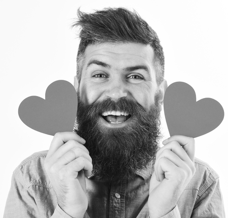 Man in love concept. Man with beard with happy face holds red heartsの写真素材
