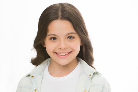 Child charming smile isolated white background close up. Charming cutie. Kid girl long curly hair posing cheerful happy. Girl curly hairstyle adorable smiling face. Kid happy carefree enjoy childhoodの写真素材