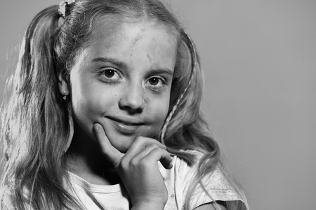 Childhood and holiday concept. Girl with nice face isolated on purple background, copy space.の写真素材