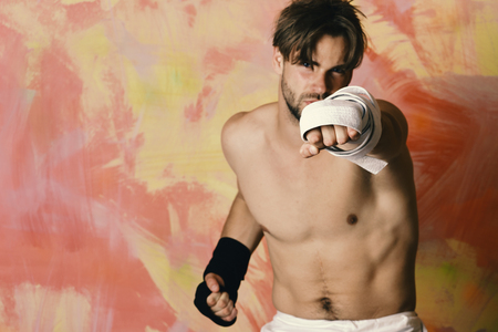 Guy with black kimono belt and bandage on arms. Japanese karate fight concept. Boxer or karate fighter practicesの写真素材