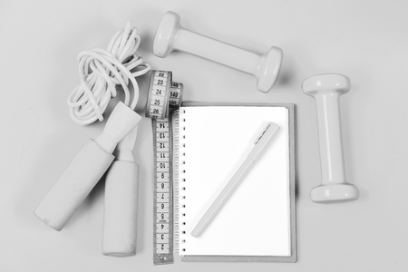 Weight loss and active lifestyle concept. Notepad and fitness tools. Block note, pen with sports equipmentの写真素材