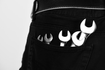 Wrench tools in jeans pocket on white background.の写真素材