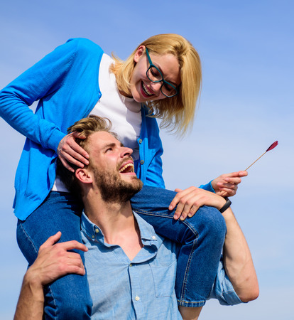 Idyllic date concept. Man carries girlfriend on shoulders, sky background. Woman enjoy perfect romantic date. Couple in love enjoy perfect date sunny day. Couple happy date having fun togetherの写真素材