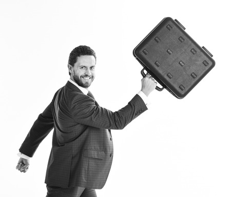 Businessman with smiling face in motion forward. Man in blue formal suit holds black case and walks.の写真素材
