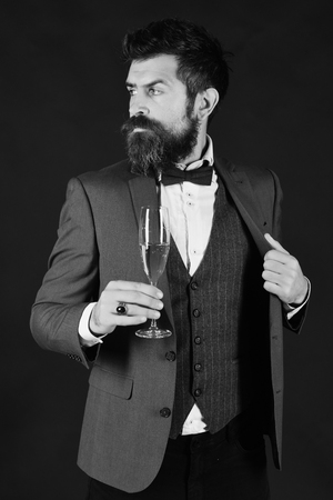 Man with beard holds glass of champagne.の写真素材