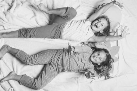 Childhood and happiness concept. Children with smiling faces lie on and hold hands upの写真素材