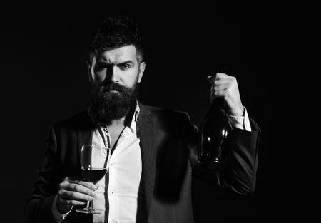 Man holding glass of cabernet or red wine and bottleの写真素材