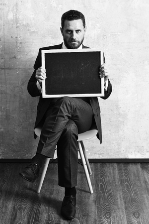 blackboard in hands of teacher man or businessman in suitの写真素材