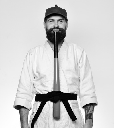 Master gets ready to fight. Martial arts concept. Baseball player with happy face puts green baseball batの写真素材