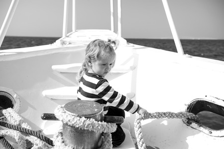 Child pull rope on yacht on sunny dayの写真素材