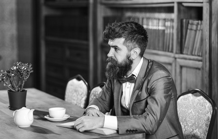 Male fashion, luxury style, work, success, business concept. Bearded man in formal suit with cup of...