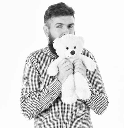Kindness, care and tenderness concept. Guy with beard hugs soft toy with tenderness.の写真素材