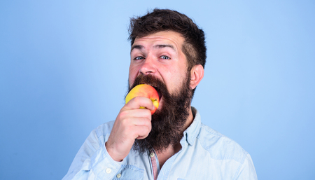 I love apples Man diet nutrition eats fruit. Healthy nutrition concept. Man handsome hipster with long beard eating apple. Hipster hungry bites juicy ripe apple. Fruit healthy snack always good ideaの写真素材