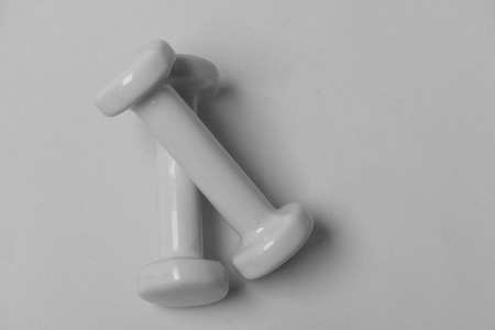 Dumbbells made of blue plastic on blue background. Barbells in small size, top view and copy space. Health regime and fitness symbols. Fit shape and sport concept.の写真素材