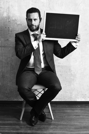 man and board. businessman holding a blackboardの写真素材