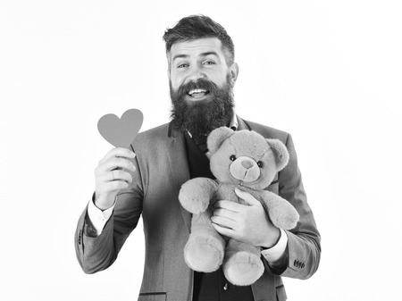 happy mature man smiling while holding teddy bear with heart and love signの写真素材