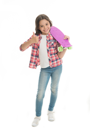 Nice board. Kid girl happy holds penny board. Modern teen hobby. Girl happy face carries penny board white background. Learning how to ride penny board. Child likes plastic skateboard shows thumbs upの写真素材