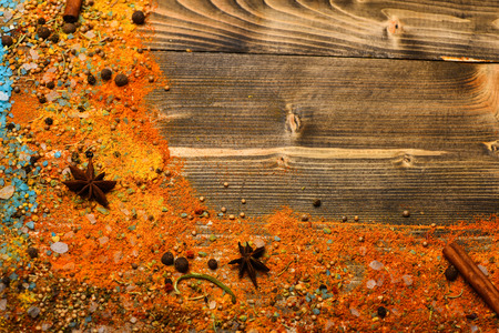 Condiments concept. Spices and ingredients on wooden texture. Condiments scattered all over surface. Cinnamon sticks, star anise, red grinded pepper and curcuma on wooden background, copy space.の写真素材