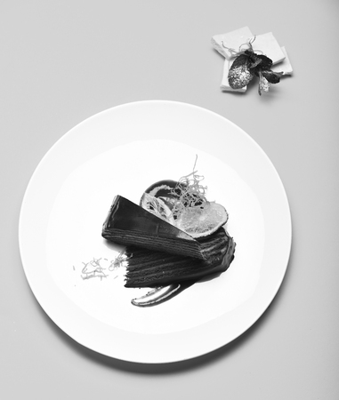 Piece of chocolate cake with many layers linked with cream. Confectionery and sweets concept. Prague chocolate cake on plate on yellow background. Delicious brownie pastry served in cafe or bakery.の写真素材