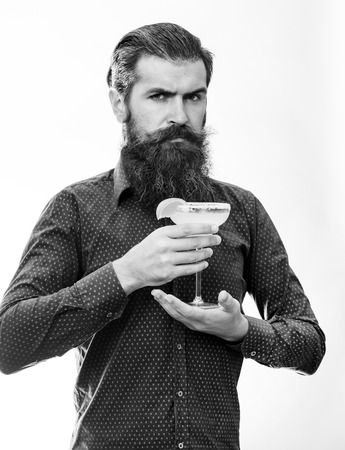 Stylish bartender concept. Hipster prepared cocktail. Barman with beard, stylish hair and strict face, isolated on white background.の写真素材