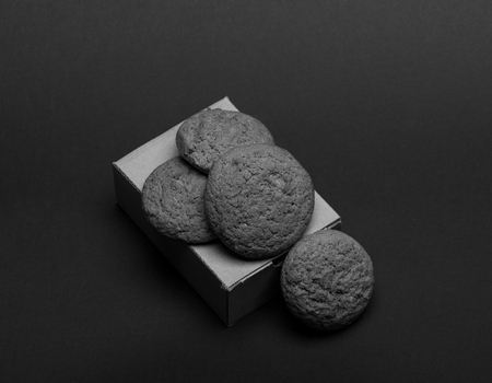 Oatmeal biscuits as tasty pastry for present. Cookies in carton box on dark grey background. Baked meal concept. Sweet bakery and delicious snack.の写真素材