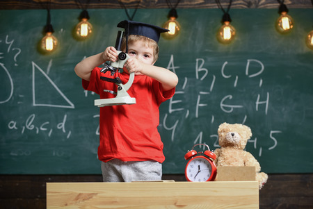 Smart kid concept. First former interested in studying, learning, education. Child on busy face near...