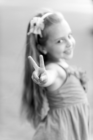 Happy child show V sign in summer parkの写真素材