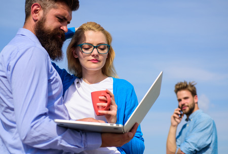 Fresh air helps to refresh mind. Colleagues laptop work outdoor sunny day, sky background. Outdoor workspace concept. Colleagues with laptop discussing plan. Friends enjoy fresh air and keep workingの写真素材