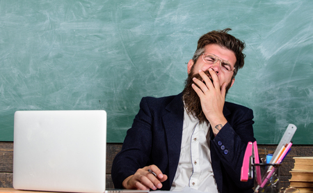 Educator bearded man yawning face tired at work. Life of teacher full of stress. Exhausting work in school causes fatigue.の写真素材