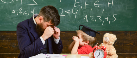 Kid cheerful boxing, beating dad. Playful child concept. Teacher and pupil in mortarboard,...