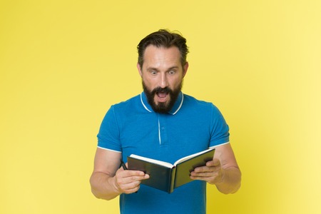 Surprise concept. Bearded man shocked with surprise. Senior man reading book with surprise. Real...