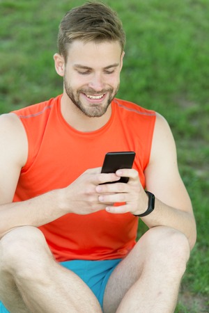 sms concept. happy man write sms on phone. sms connection and online blogging. smiling man writing sms message to somebody. lovely message from her.の写真素材