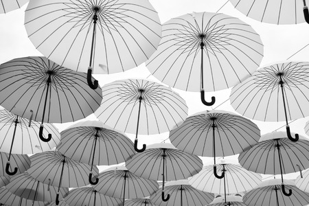 Umbrellas float in sky on sunny day. Umbrella sky project installation. Outdoor art design and decor. Holiday and festival celebration. Shade and protection.の写真素材