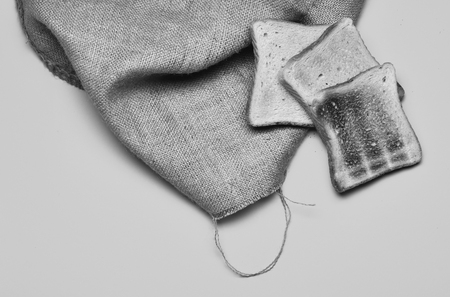 Pieces of white toast bread on sackcloth on yellow background. Bread slices lying on each other, top view. American breakfast conceptの写真素材