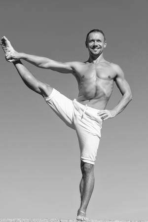 I enjoy pilates. Man do muscle stretching. Muscular man enjoy good health. Health care. Achieving success in sport. Sport and fitness. Success is no accident, black and white.の写真素材