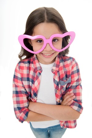 Kid happy lovely feels sympathy. Child charming smile fall in love. Girl heart shaped eyeglasses celebrates valentines day. Girl cute smiling face heart glasses. Love symbol concept. Childhood love.の写真素材