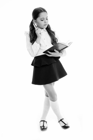 Schoolgirl read book isolated on white. Little child hold textbook with pen. Dedicated to study. Back to school. Home schooling education. Knowledge day. Adorable bookworm. Back to school.の写真素材